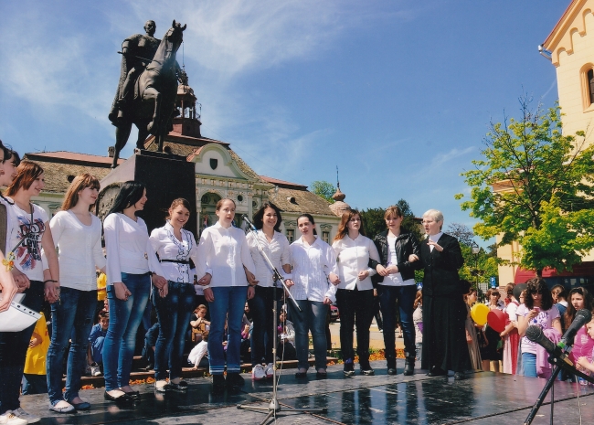 A kollégium Ave Maris Stella kórusával magyar népdalokat énekelnek Nagybecskerek főterén